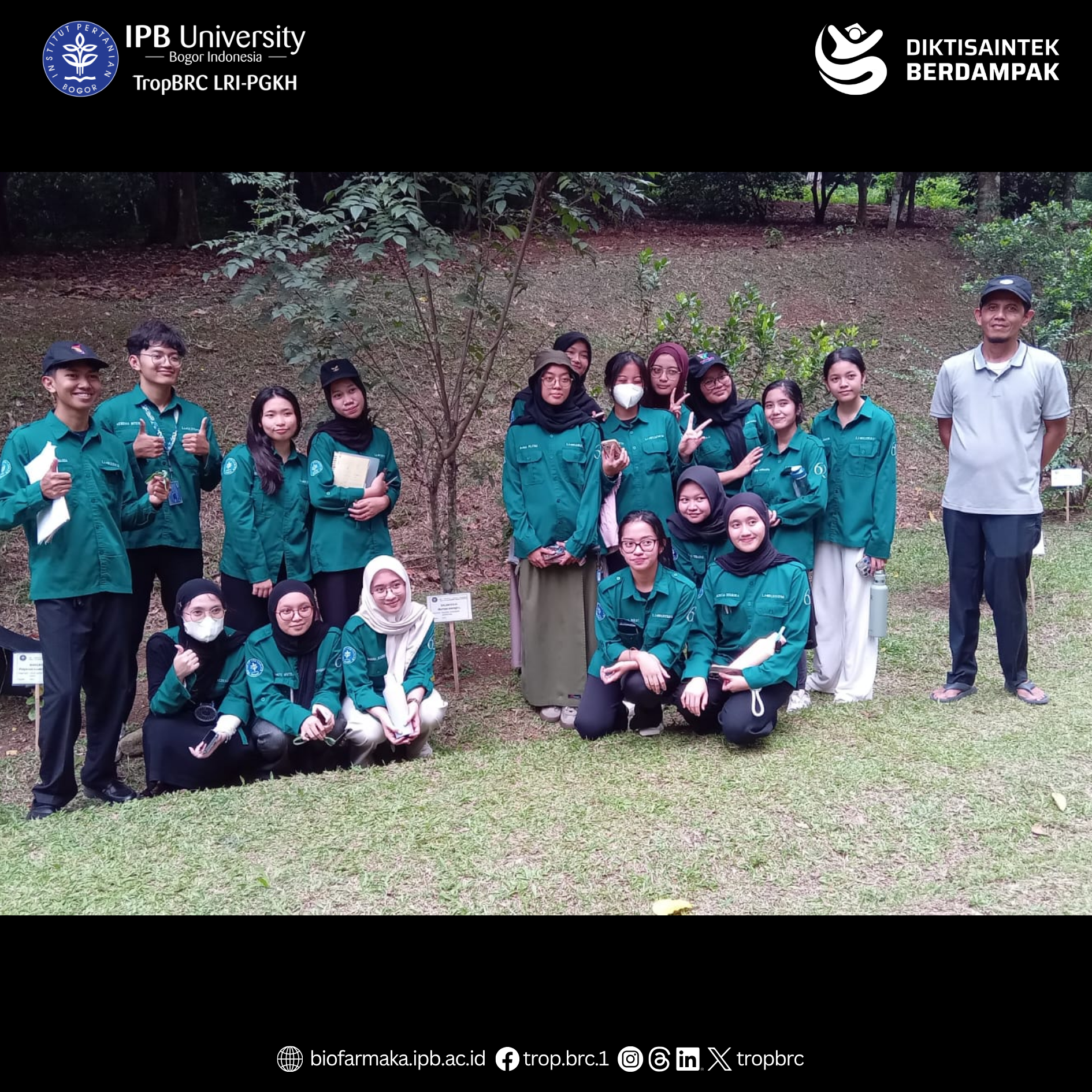 Students and supervisors take a group picture on the grass after an outdoor lesson on tropical medicinal plants.